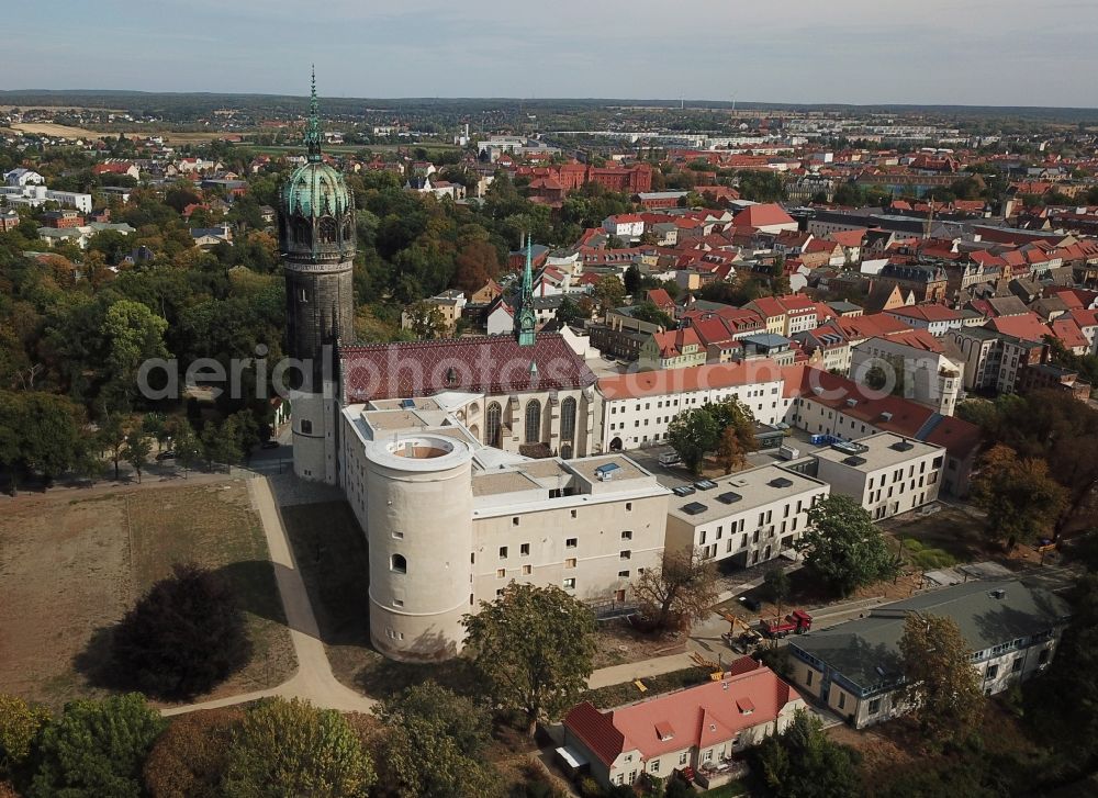 Aerial photograph Lutherstadt Wittenberg - Castle church of Wittenberg. The castle with high Gothic tower at the west end of the town is a UNESCO World Heritage Site. It gained fame as the Wittenberg Augustinian monk and theology professor Martin Luther spread his disputation