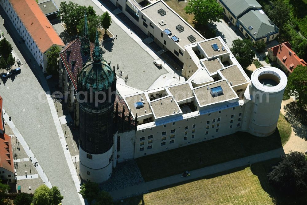 Aerial photograph Lutherstadt Wittenberg - Castle church of Wittenberg. The castle with its 88 m high Gothic tower at the west end of the town is a UNESCO World Heritage Site. It gained fame as the Wittenberg Augustinian monk and theology professor Martin Luther spread his disputation
