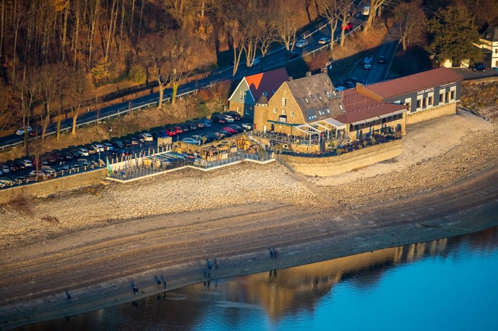 Möhnesee from the bird's eye view: Bank areas with low water level at Moehnesee and the restaurant Sabe Mente Moehnesee in Moehnesee in the federal state of North Rhine-Westphalia, Germany