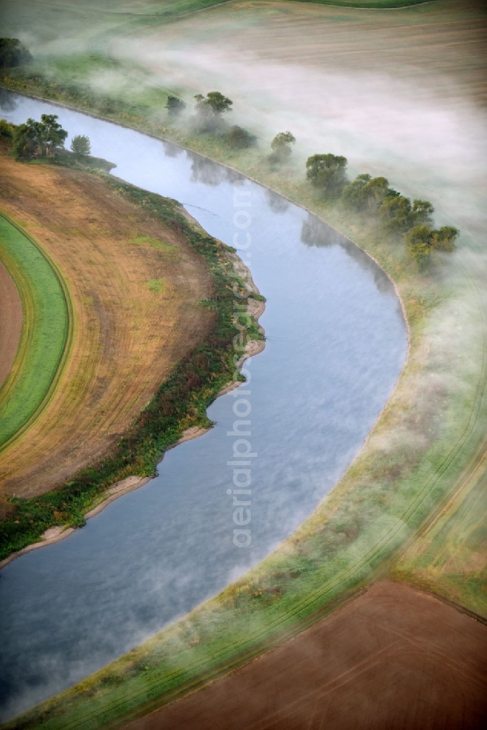 Groß Rosenburg from the bird's eye view: Fog swirling over a meadow and field landscape on curved loop of the riparian zones on the course of the river of Saale in Gross Rosenburg in the state Saxony-Anhalt, Germany