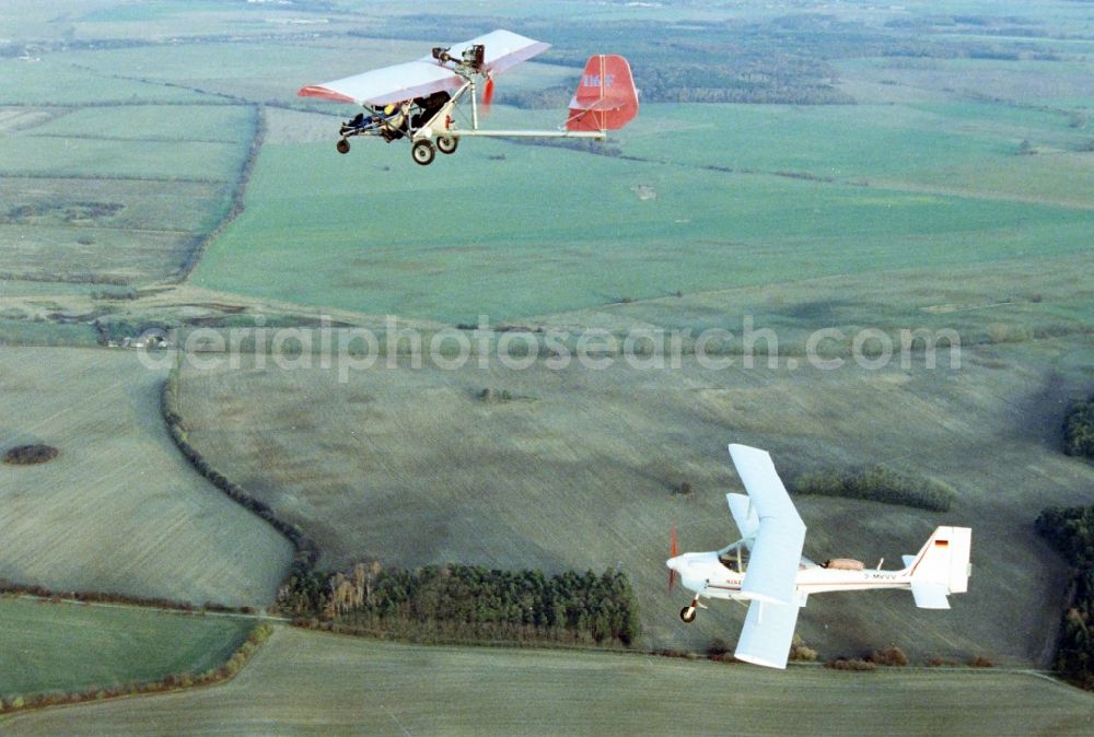 Eggersdorf from the bird's eye view: Ultralight aircraft in flight above the sky MISTRAL with the identifier D-MVVV in formation with a skywalker airplane in Eggersdorf in the state Brandenburg, Germany