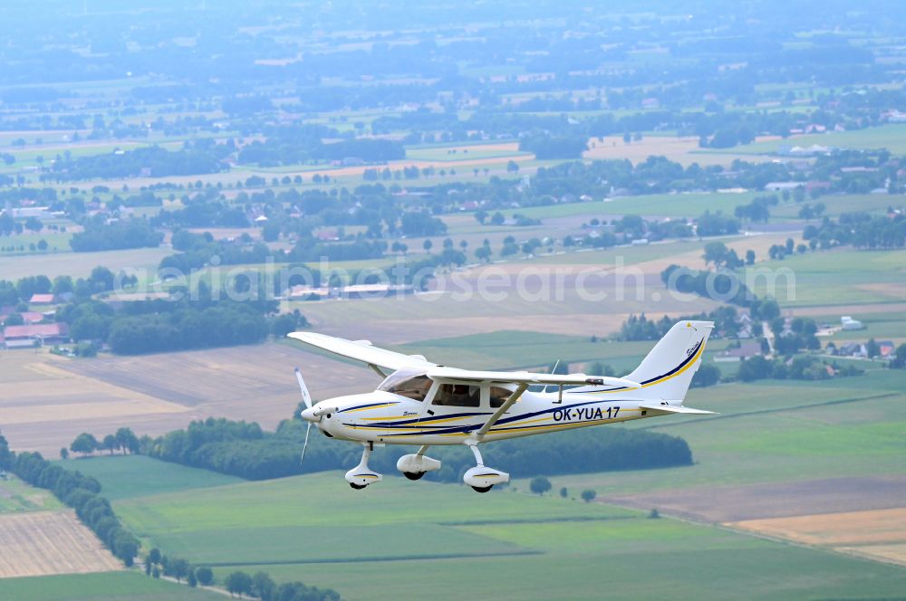 Wagenfeld from the bird's eye view: Ultralight aircraft TL-3000 Sirius with the identifier OK-YUA17 in flight above the sky in Wagenfeld in the state Lower Saxony, Germany