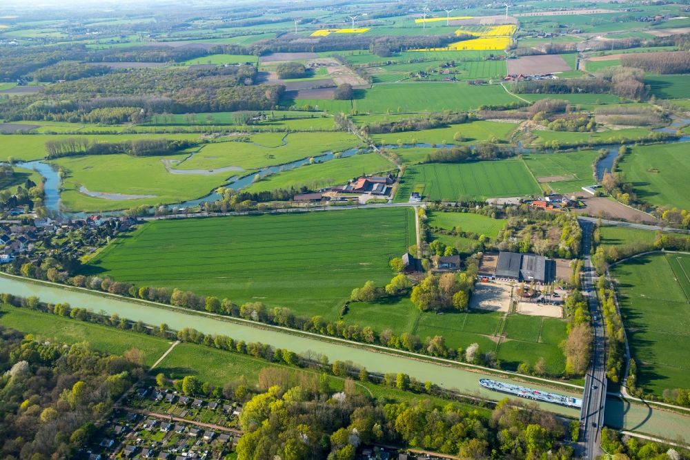 Aerial photograph Hamm - Surrounding area of the Datteln-Hamm-Canal in the North of the Werris part of Hamm in the state of North Rhine-Westphalia. A bridge with the Ostwennemarstrasse takes its course across the canal. A stable and riding facilities are located on the riverbank