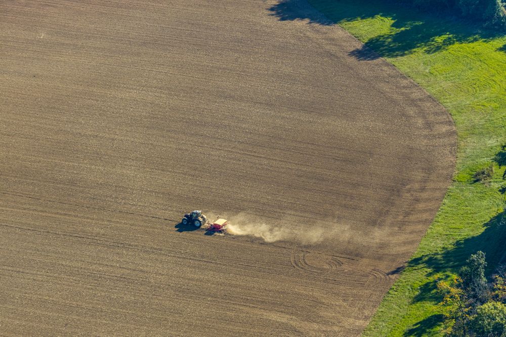 Aerial photograph Gehrden - Plowing and shifting the earth by a tractor with plow on agricultural fields on street Escherfeld in Gehrden in the state North Rhine-Westphalia, Germany