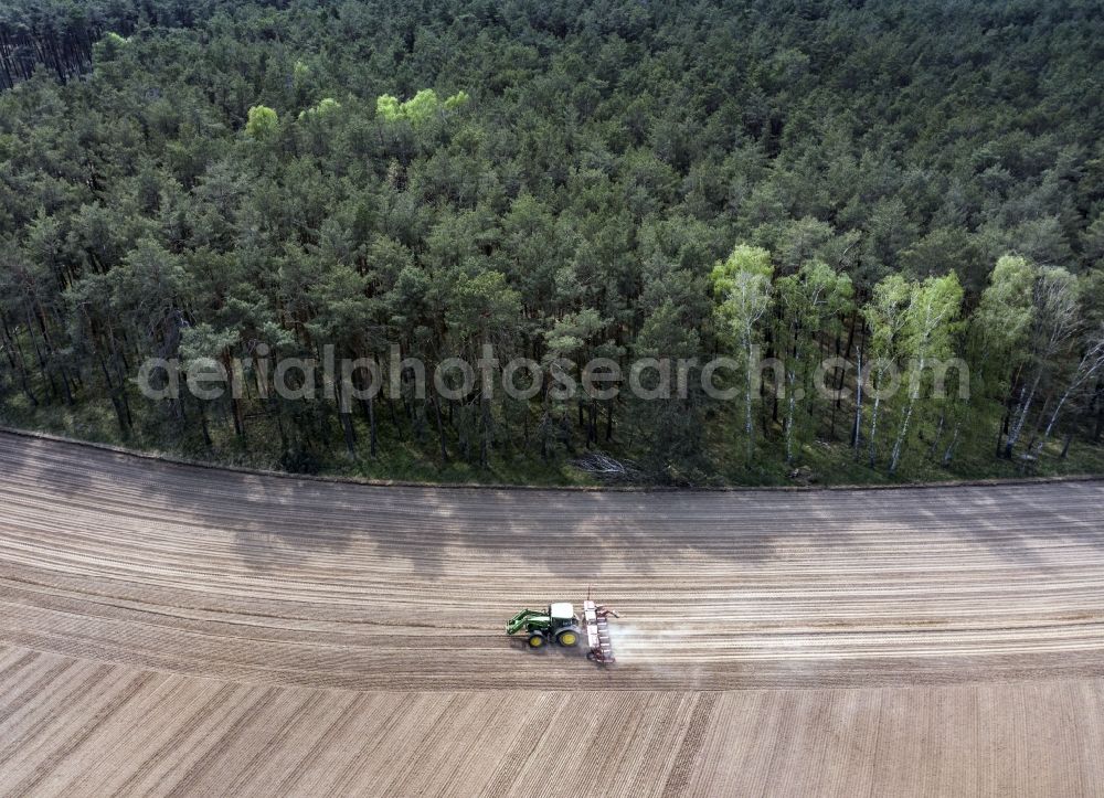 Aerial image Haseloff - Plowing and shifting the earth by a tractor with plow on agricultural fields in Haseloff in the state Brandenburg, Germany