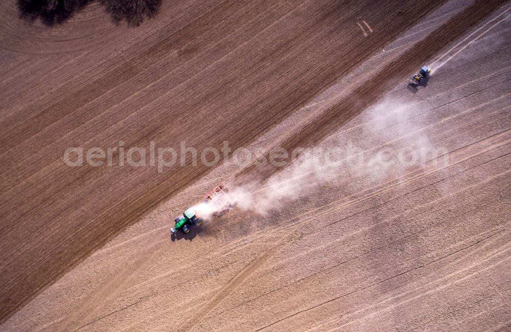Aerial photograph Jürgenshagen - Plowing and shifting the earth by a tractor with plow on agricultural fields in Juergenshagen in the state Mecklenburg - Western Pomerania, Germany