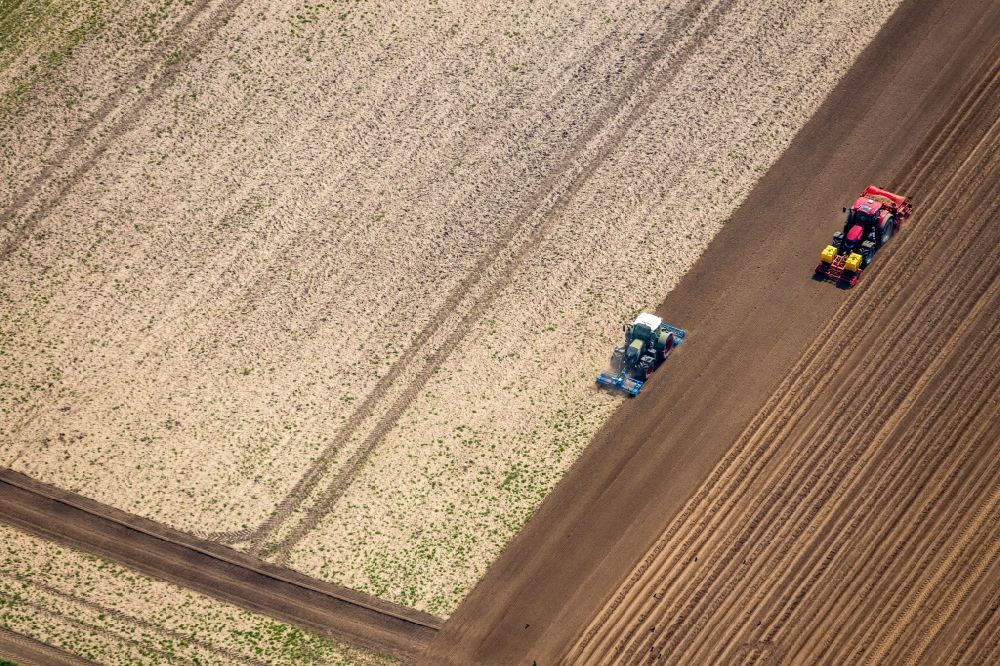 Aerial photograph Rees - Plowing and shifting the earth by a tractor with plow on agricultural fields in Rees in the state North Rhine-Westphalia, Germany