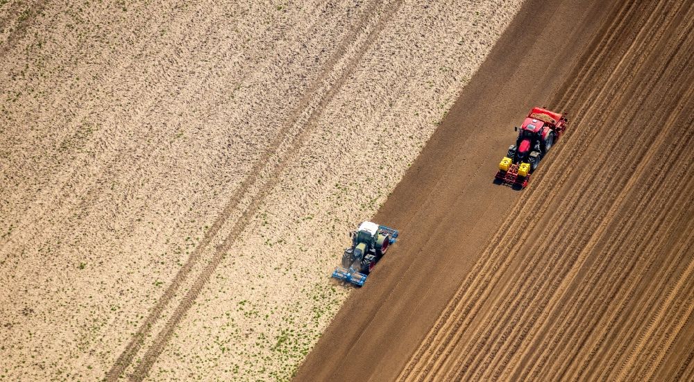 Rees from above - Plowing and shifting the earth by a tractor with plow on agricultural fields in Rees in the state North Rhine-Westphalia, Germany