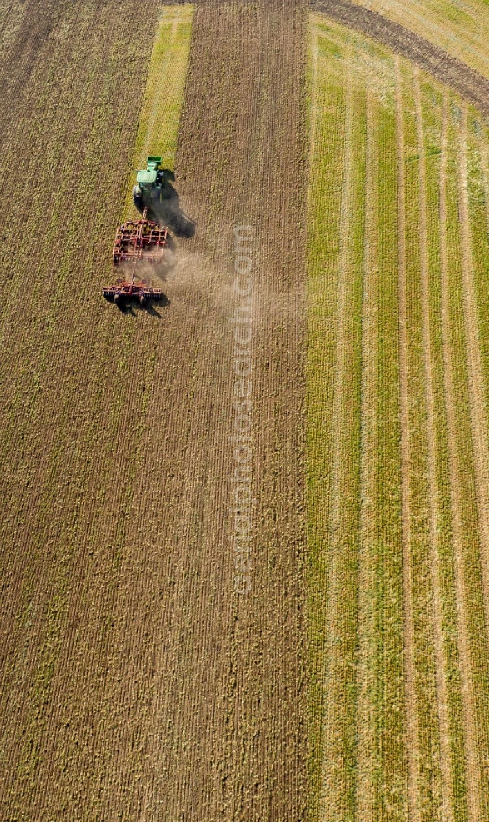 Aerial photograph Teutschenthal - Plowing and shifting the earth by a tractor with plow on agricultural fields in Teutschenthal in the state Saxony-Anhalt, Germany