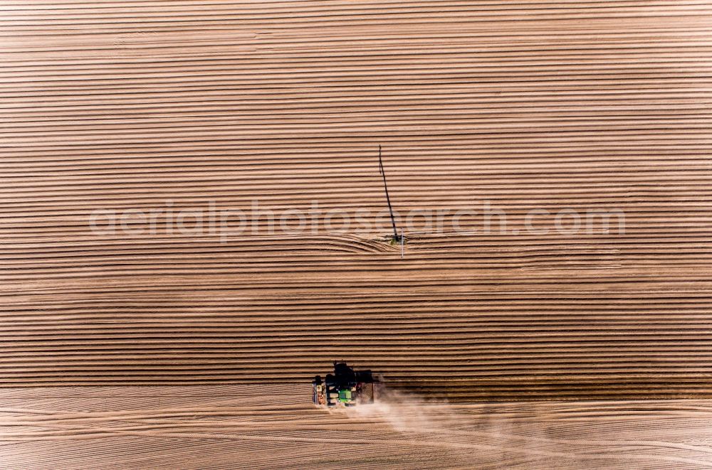 Aerial photograph Wittenbeck - Plowing and shifting the earth by a tractor with plow on agricultural fields in Wittenbeck in the state Mecklenburg - Western Pomerania, Germany
