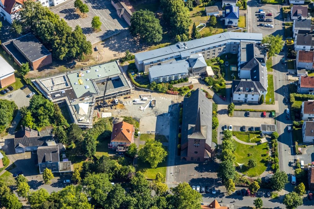 Aerial photograph Hamm - Building of the indoor arena Haus der Begegnung for the community and all-day school overlooking the Katholische Kirche Heilig Kreuz and the Caritas-Altenheim St. Josef in the district Herringen in Hamm in the state North Rhine-Westphalia, Germany