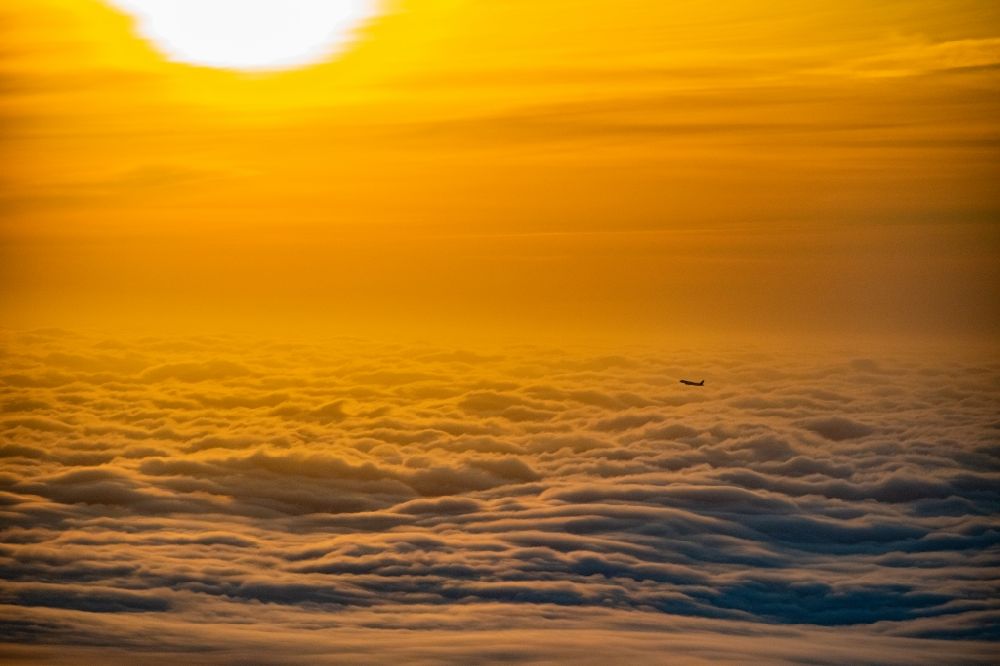 Aerial image Norderstedt - Airliner in the sunrise over the clouds after take-off in Hamburg Fuhlsbuettel in the height of Norderstedt in the state Schleswig-Holstein Germany