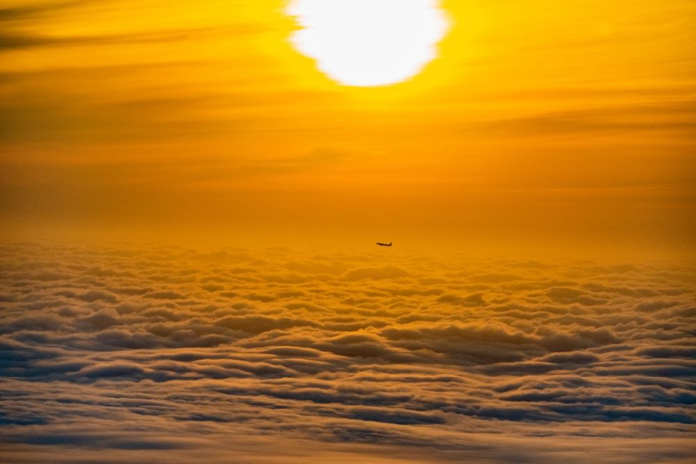 Aerial photograph Norderstedt - Airliner in the sunrise over the clouds after take-off in Hamburg Fuhlsbuettel in the height of Norderstedt in the state Schleswig-Holstein Germany