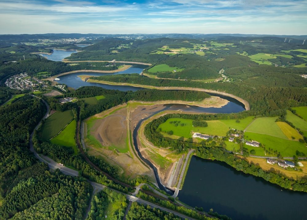Olpe from the bird's eye view: Dam and shore areas at the lake Biggetalsperre in Olpe in the state North Rhine-Westphalia. A lowered water level allows repair works at the dam near the Eichhagen part of the town