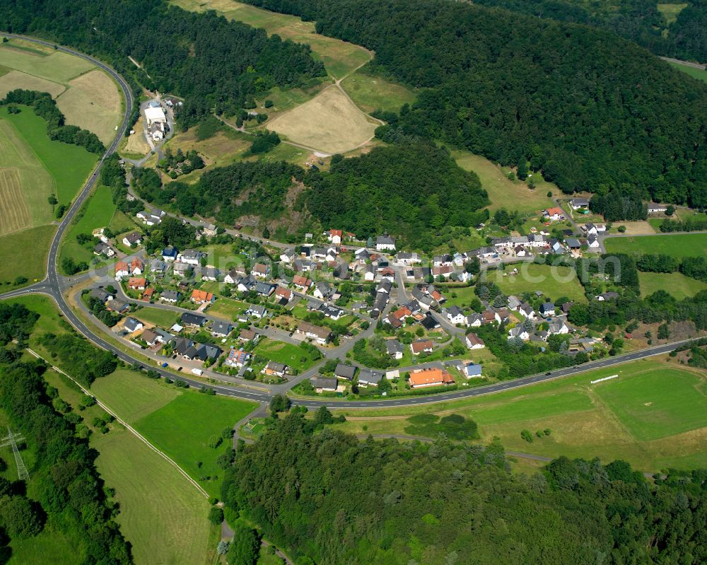 Amdorf from above - Surrounded by forest and forest areas center of the streets and houses and residential areas in Amdorf in the state Hesse, Germany