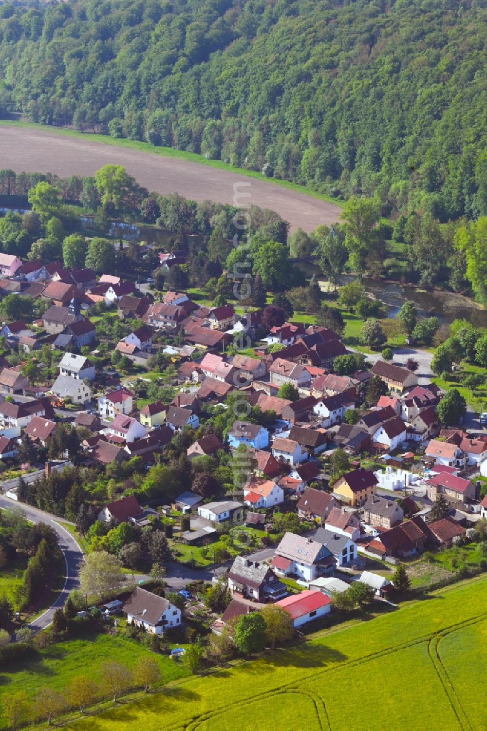 Ebenshausen from above - Surrounded by forest and forest areas center of the streets and houses and residential areas in Ebenshausen in the state Thuringia, Germany