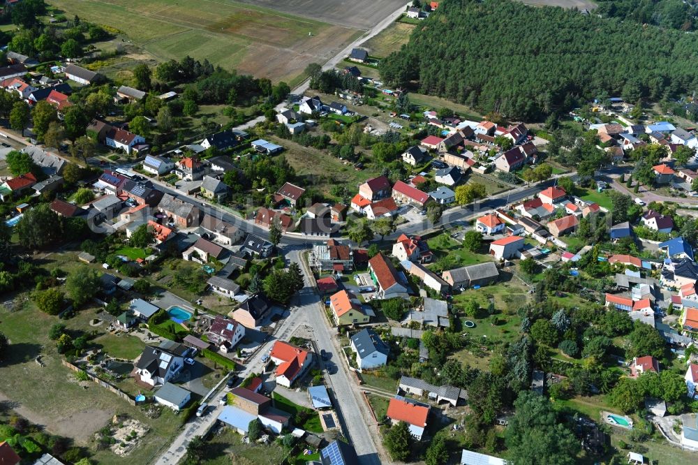 Am Mellensee from above - Surrounded by forest and forest areas center of the streets and houses and residential areas in Am Mellensee in the state Brandenburg, Germany