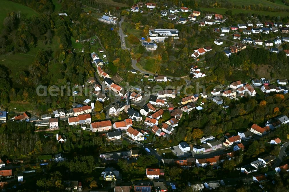 Aerial image Niederkirchen - Surrounded by forest and forest areas center of the streets and houses and residential areas in Niederkirchen in the state Saarland, Germany