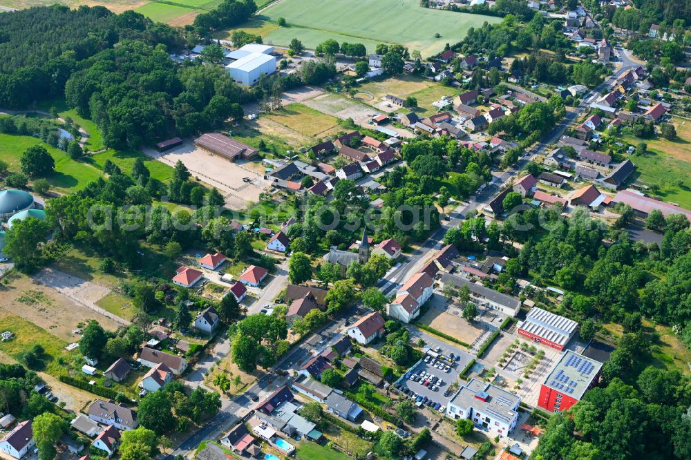 Aerial photograph Schmachtenhagen - Surrounded by forest and forest areas center of the streets and houses and residential areas in Schmachtenhagen in the state Brandenburg, Germany