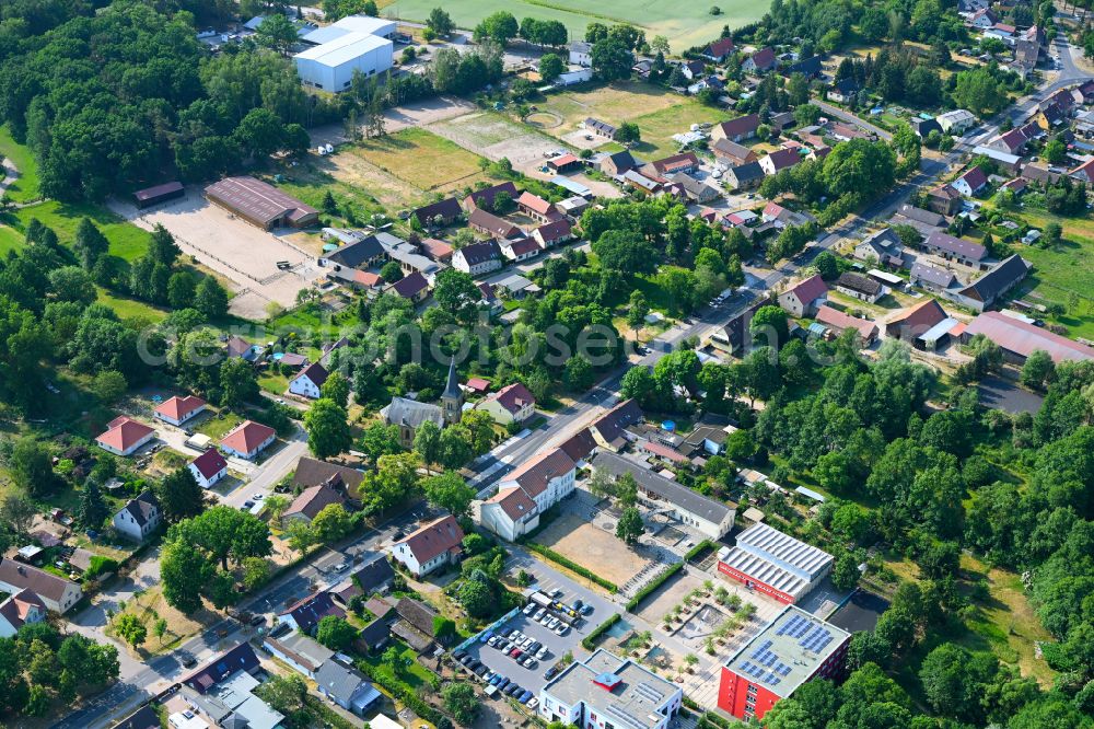 Aerial image Schmachtenhagen - Surrounded by forest and forest areas center of the streets and houses and residential areas in Schmachtenhagen in the state Brandenburg, Germany