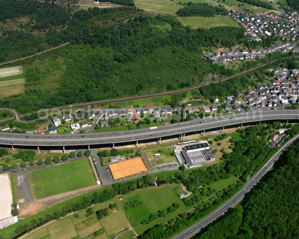 Aerial photograph Sechshelden - Surrounded by forest and forest areas center of the streets and houses and residential areas in Sechshelden in the state Hesse, Germany