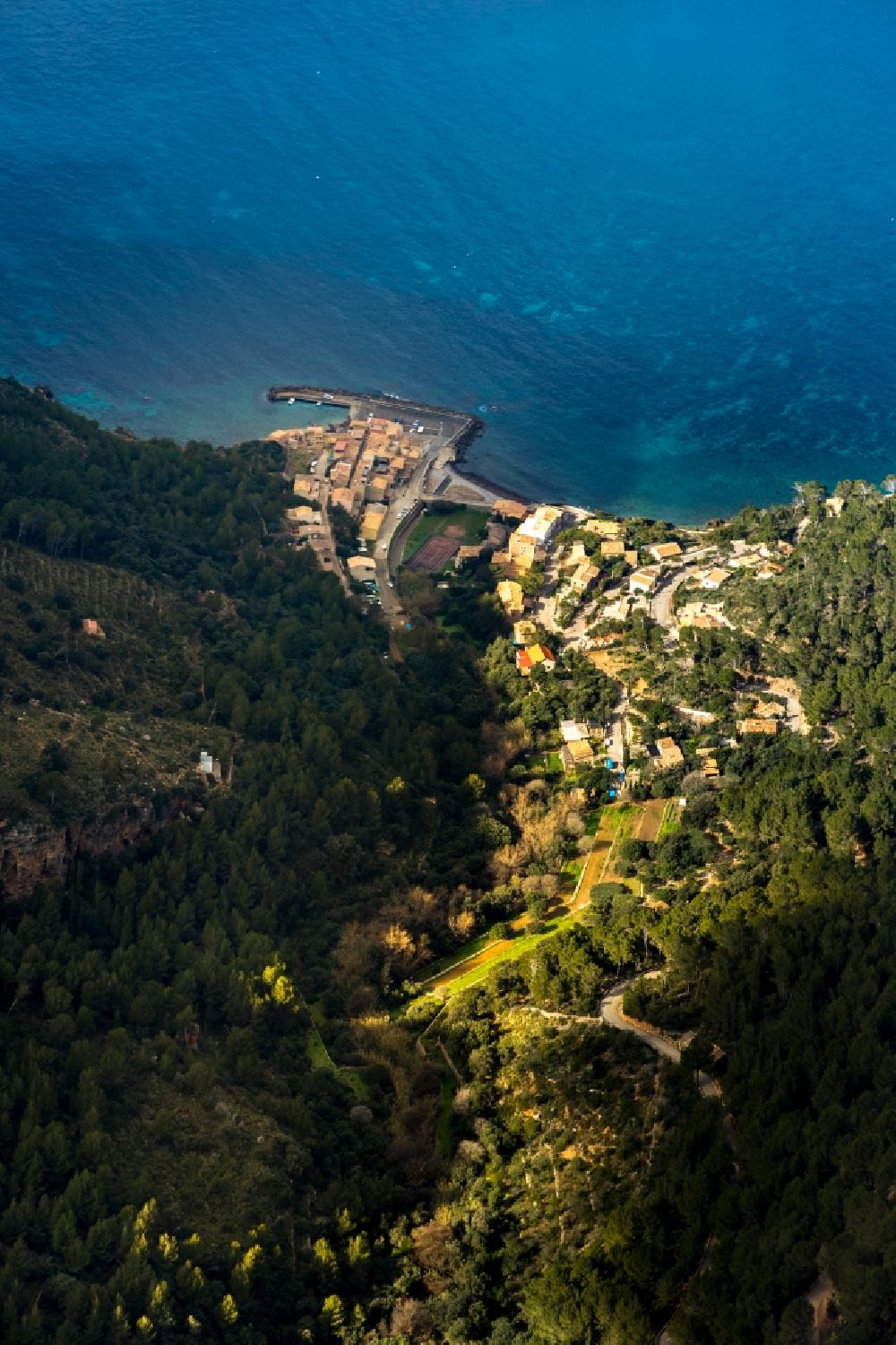 Valldemossa from the bird's eye view: Surrounded by forest and forest areas center of the streets and houses and residential areas in Valldemossa in Balearic island of Mallorca, Spain