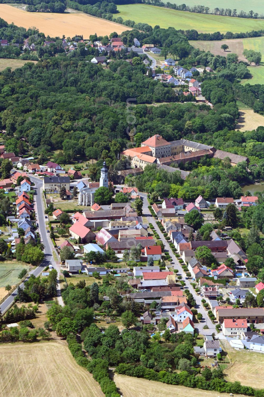 Aerial image Wölkau - Surrounded by forest and forest areas center of the streets and houses and residential areas in Woelkau in the state Saxony, Germany