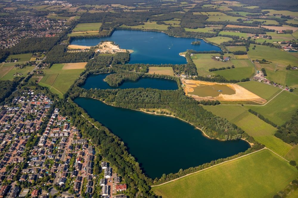 Aerial photograph Hünxe - Forests on the shores of Lake Tenderingssee overlooking the gravel opencast in Huenxe in the state North Rhine-Westphalia, Germany