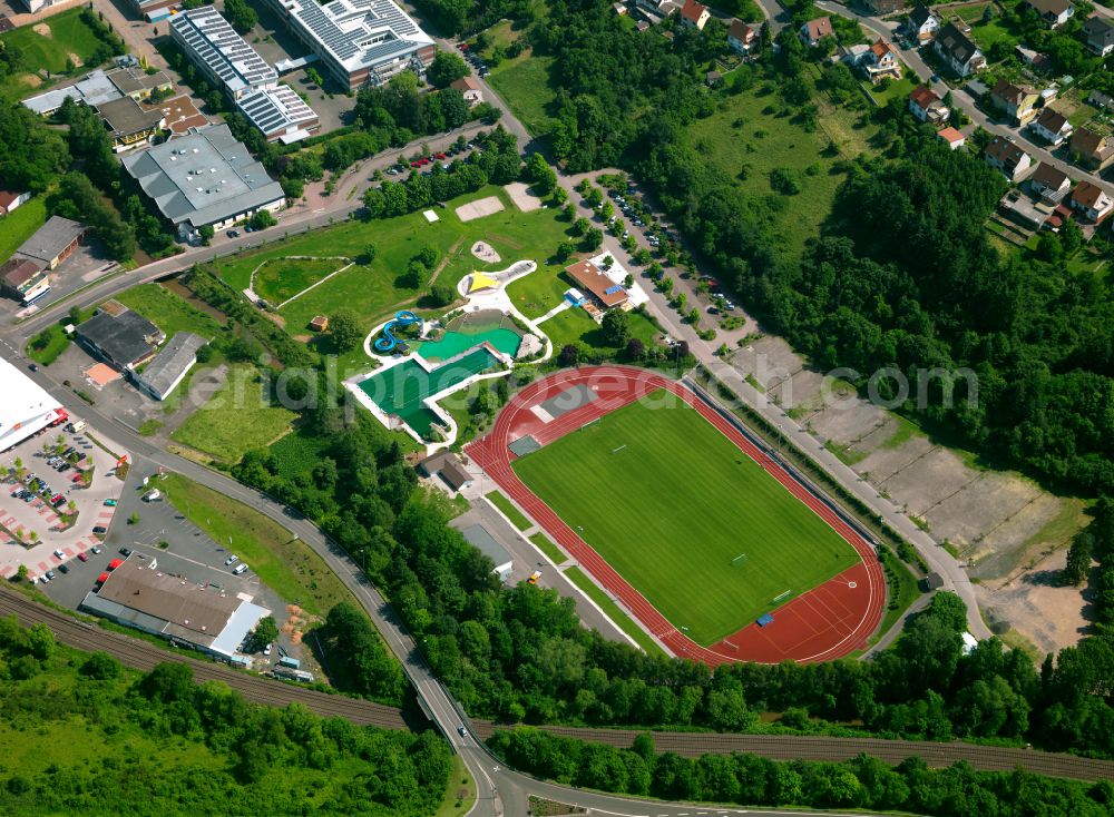 Rockenhausen from above - Waterslide at the swimming pool of the Natur-Erlebnisbad Rockenhausen and the sports ground- Ensemble of the Stadion Obermuehle on street Muehlackerweg - Obermuehle in Rockenhausen in the state Rhineland-Palatinate, Germany