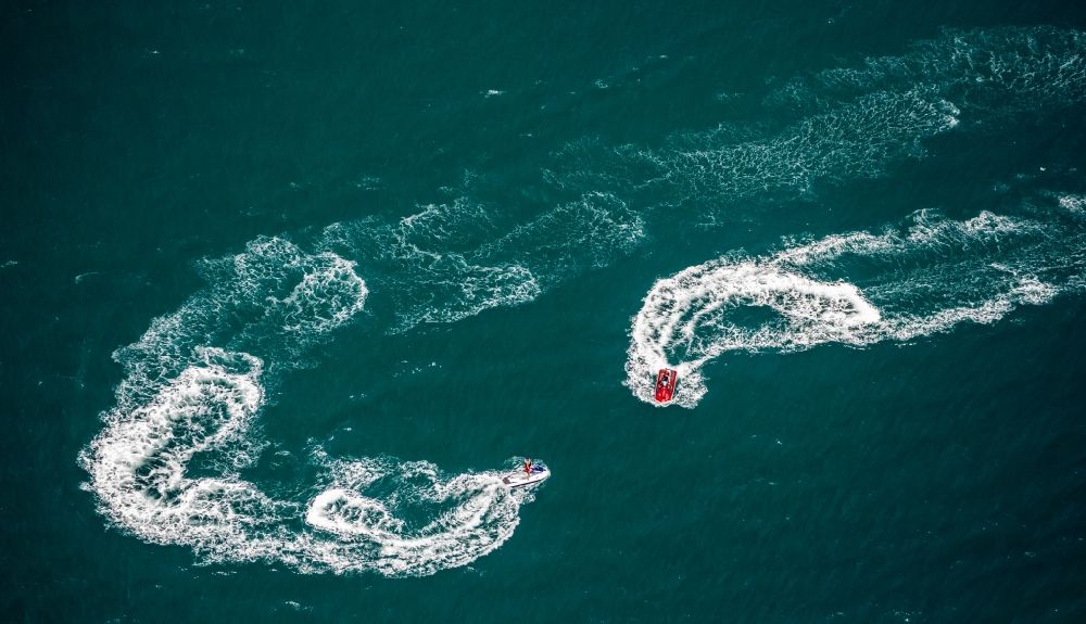 Agde from the bird's eye view: By waves and foam crests of watersports curves and circular drive with turbulence Mediterranean surface water off the coast in Agde in France