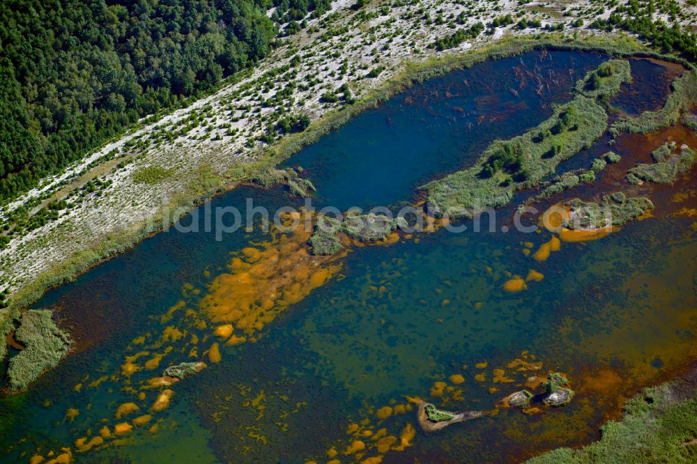 Kolonie Fortschritt from above - Colorful water surface and water discoloration in open-cast mining, overburden and residual areas due to sulfuric acid compounds and oxidized iron compounds These are dissolved by rising groundwater and lead to acidification and clogging of the water. in Kolonie Fortschritt in the state Brandenburg, Germany