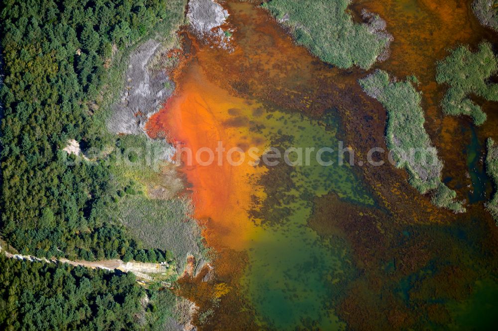 Aerial photograph Kolonie Fortschritt - Colorful water surface and water discoloration in open-cast mining, overburden and residual areas due to sulfuric acid compounds and oxidized iron compounds These are dissolved by rising groundwater and lead to acidification and clogging of the water. in Kolonie Fortschritt in the state Brandenburg, Germany