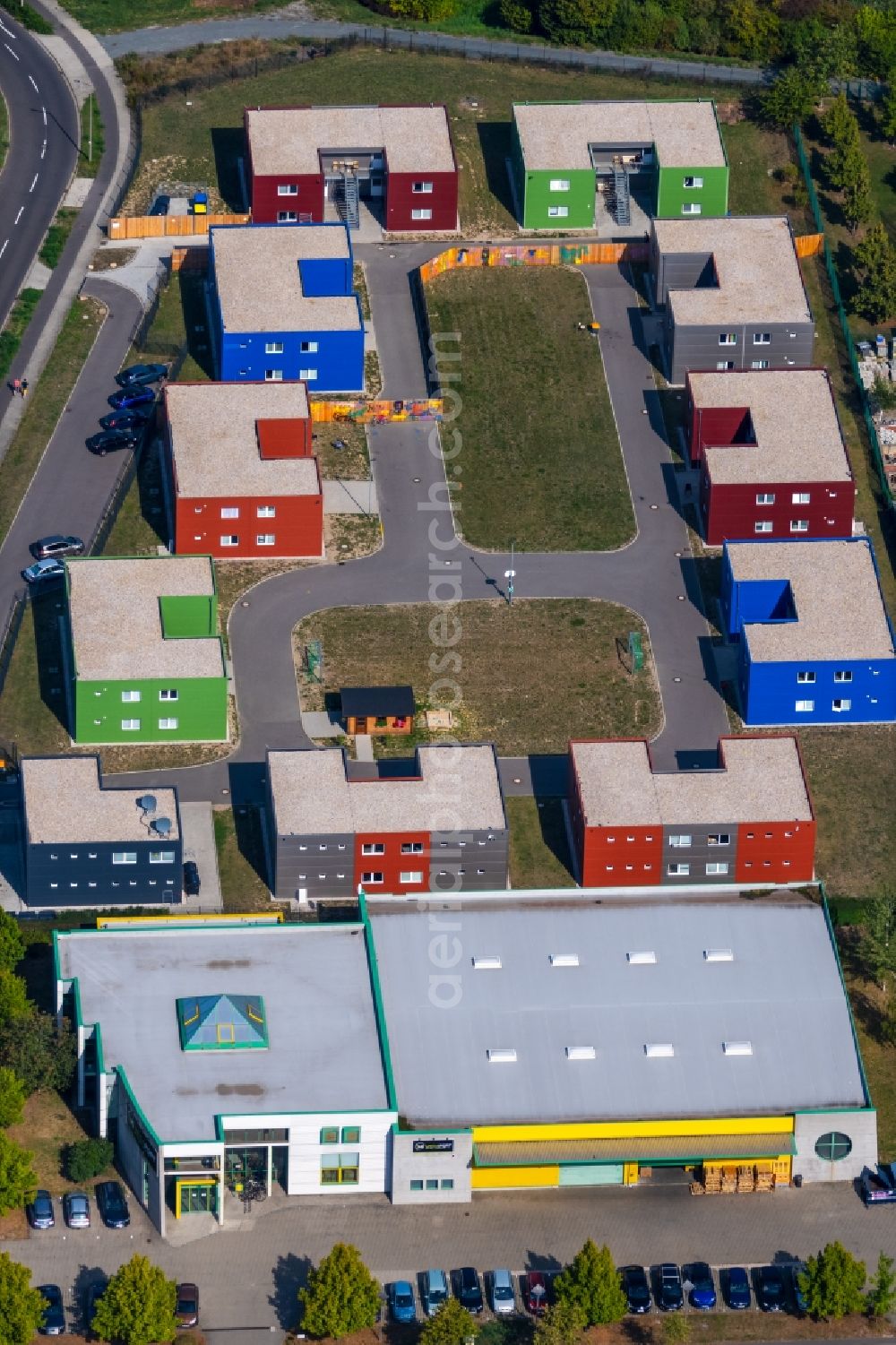 Leipzig from the bird's eye view: Building and production halls on the premises of Megaport GmbH on Heiterblickstrasse overlooking the refugee home and asylum accommodation buildings on Braunstrasse in the district Schoenefeld in Leipzig in the state Saxony, Germany