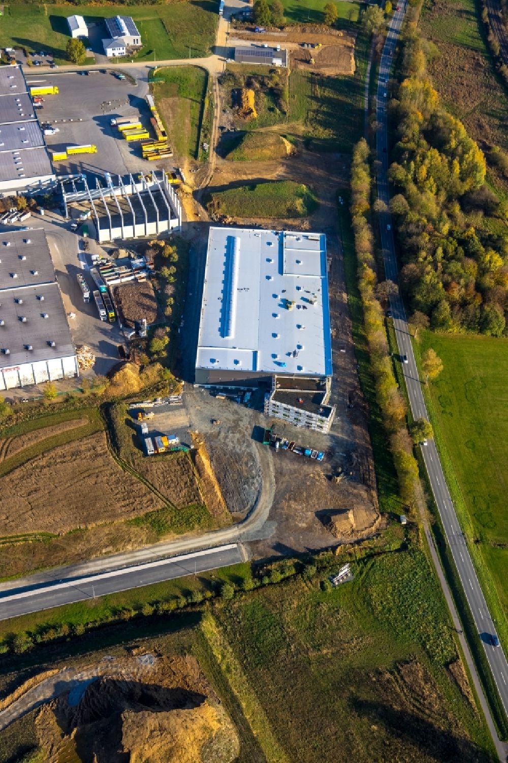 Meschede from the bird's eye view: Building and production halls on the premises of R.A.B.E. Abfallaufbereitung GmbH overlooking a construction site Am Steinbach in the district Enste in Meschede in the state North Rhine-Westphalia, Germany