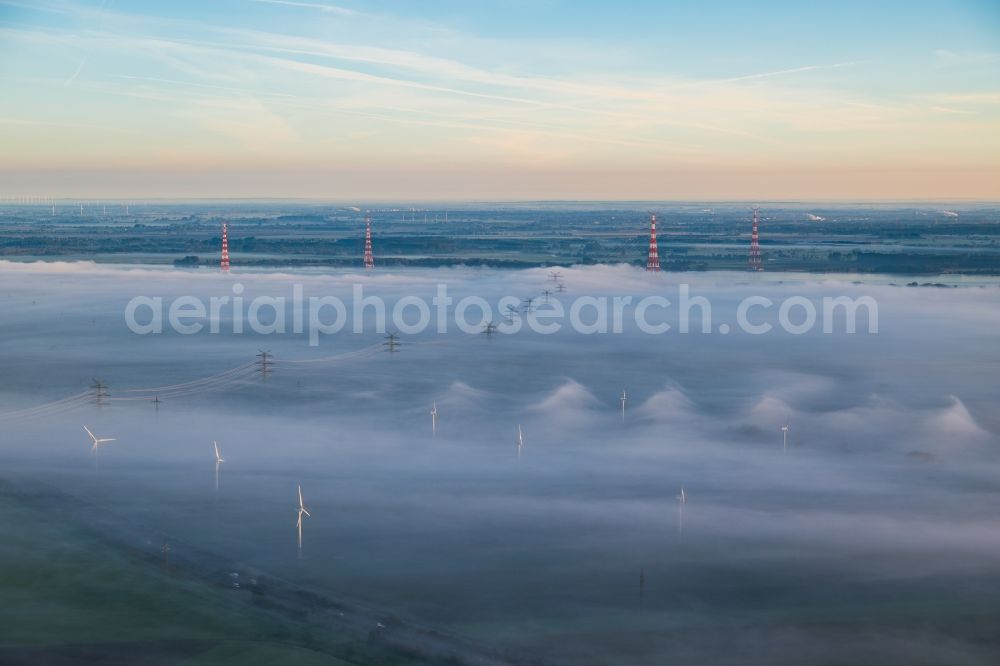 Hollern-Twielenfleth from above - Weather-induced wind energy installations embedded in a fog layer in Hollern-Twielenfleth in the state Lower Saxony, Germany