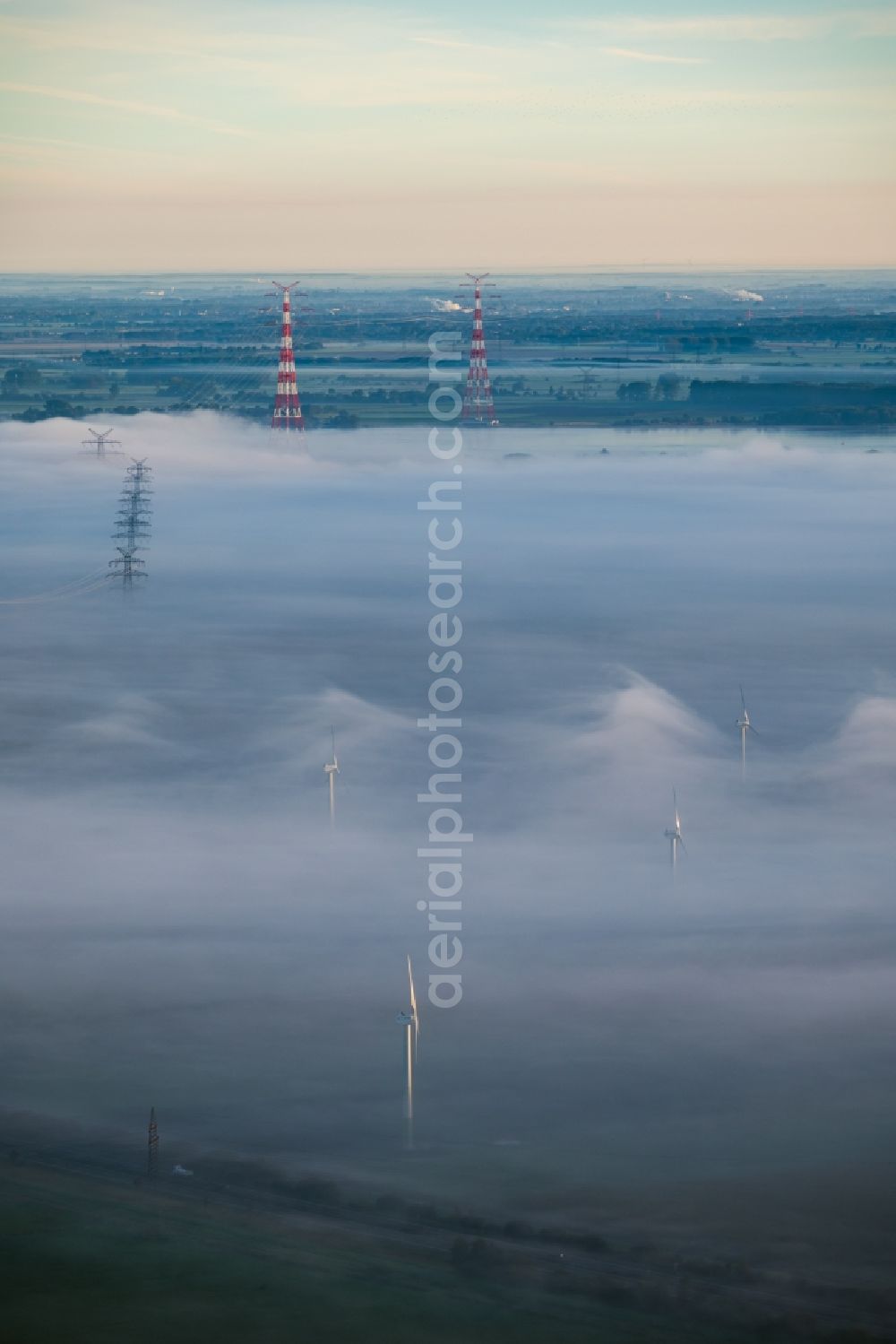 Hollern-Twielenfleth from the bird's eye view: Weather-induced wind energy installations embedded in a fog layer in Hollern-Twielenfleth in the state Lower Saxony, Germany