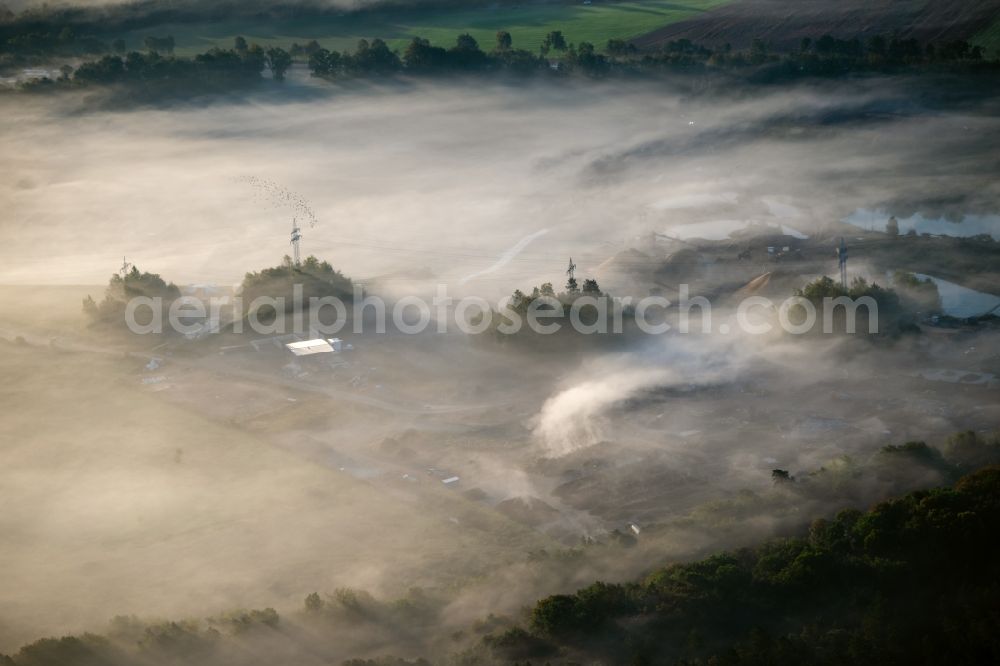 Rosengarten from above - Due to weather conditions embedded in a layer of fog site and tailings area an landfill site of the gravel mining in Rosengarten in the state Lower Saxony, Germany