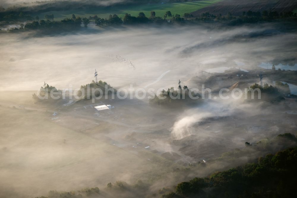 Rosengarten from the bird's eye view: Due to weather conditions embedded in a layer of fog site and tailings area an landfill site of the gravel mining in Rosengarten in the state Lower Saxony, Germany