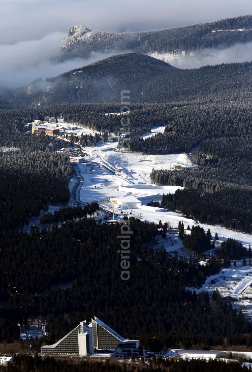 Oberhof from above - Winter landscape of snow-covered ski track with indoor skiing and the hotel Panorama in Oberhof in Thuringia