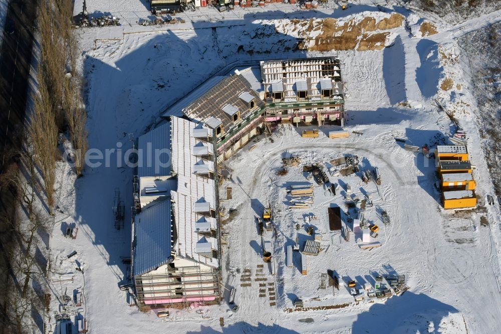 Aerial photograph Werneuchen - Wintery snowy construction site for the new building an office and administration building der Berger Bau GmbH at Alte Hirschfelder Strasse in Werneuchen in the state Brandenburg