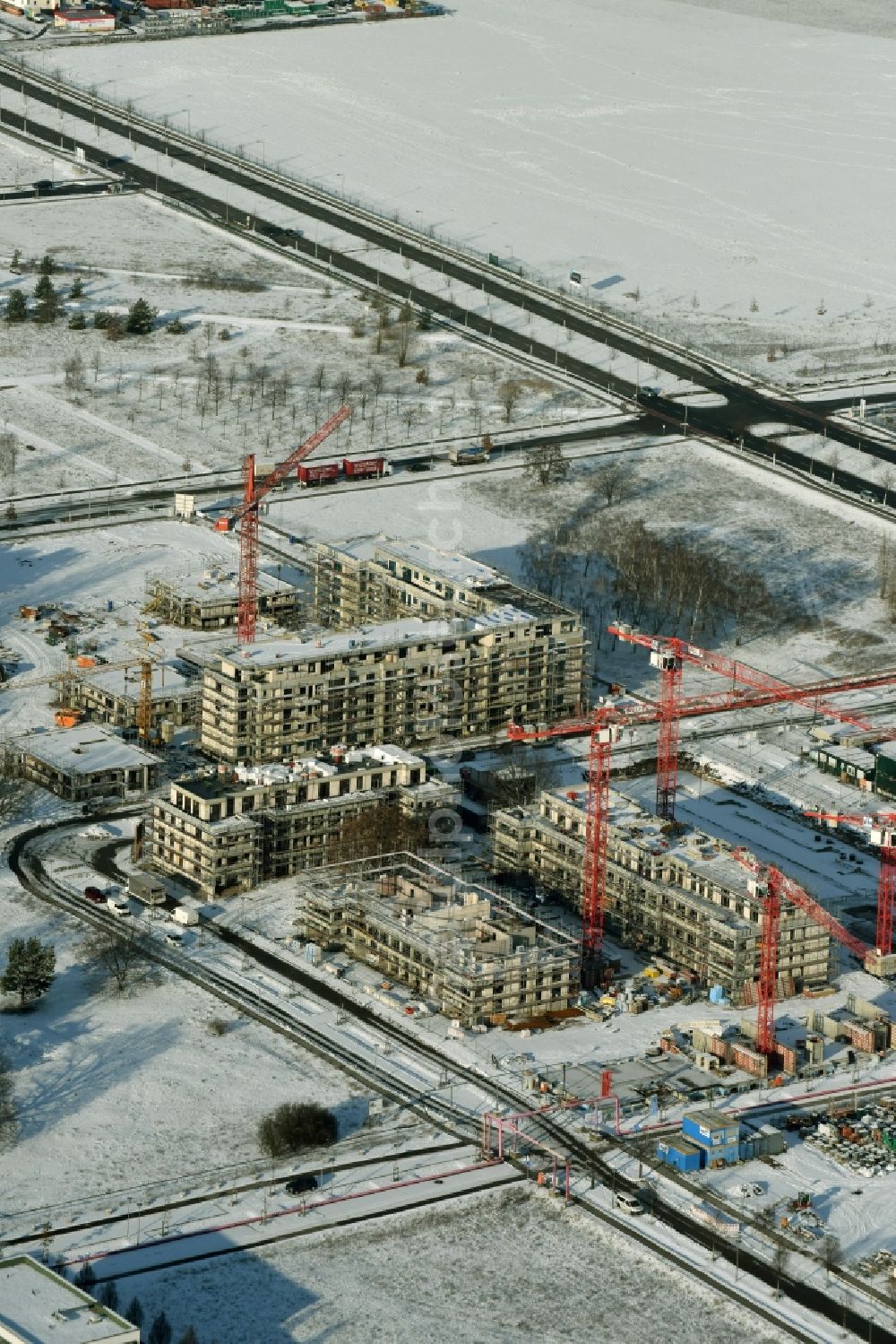 Aerial photograph Berlin - Snow-covered construction site of a new multi-family residential complex „Wohnen am Campus“ on Wilhelm-Hoff-Strasse in the technology park Adlershof in Berlin in Germany