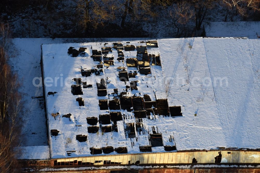 Oberkrämer from the bird's eye view: Wintery snow- covered roof holes in the ruins of the former airfield hangars on the abandoned military airfield in Schoenwalde in Brandenburg