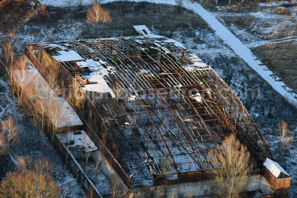 Aerial photograph Oberkrämer - Wintery snow- covered roof holes in the ruins of the former airfield hangars on the abandoned military airfield in Schoenwalde in Brandenburg