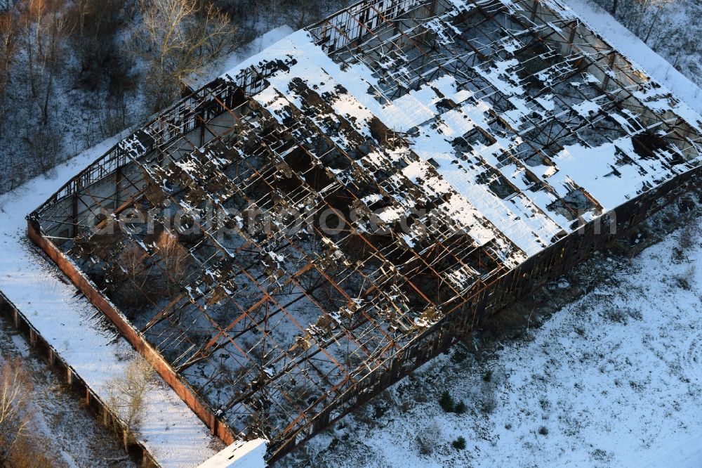 Oberkrämer from above - Wintery snow- covered roof holes in the ruins of the former airfield hangars on the abandoned military airfield in Schoenwalde in Brandenburg