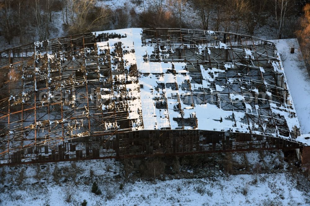Aerial photograph Oberkrämer - Wintery snow- covered roof holes in the ruins of the former airfield hangars on the abandoned military airfield in Schoenwalde in Brandenburg