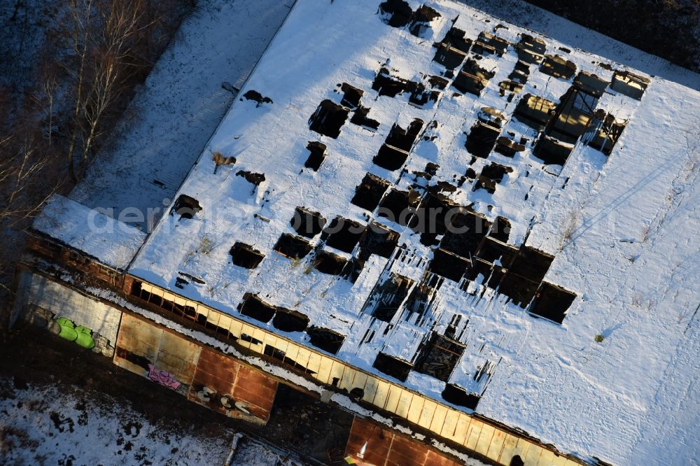 Oberkrämer from the bird's eye view: Wintery snow- covered roof holes in the ruins of the former airfield hangars on the abandoned military airfield in Schoenwalde in Brandenburg