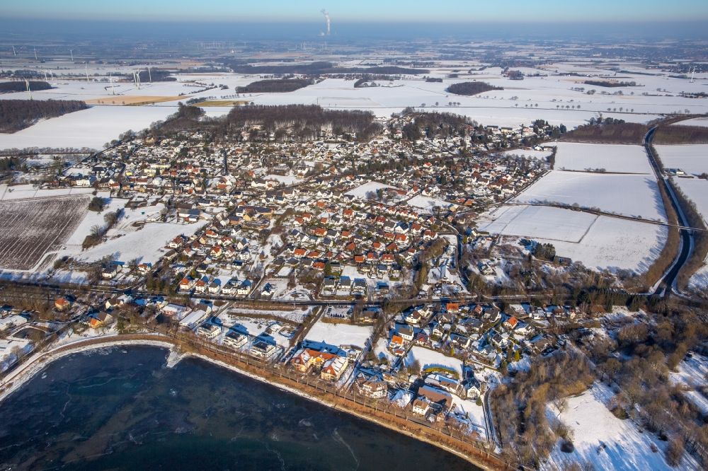 Aerial photograph Möhnesee - Wintry snowy townscape with streets and houses of the residential areas in the district Guenne in Moehnesee in the state North Rhine-Westphalia