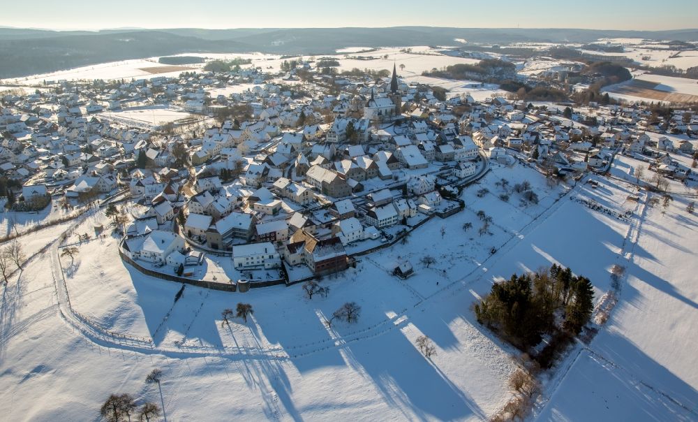 Rüthen from the bird's eye view: Wintry snowy townscape with streets and houses of the residential areas in the district Kallenhardt in Ruethen in the state North Rhine-Westphalia