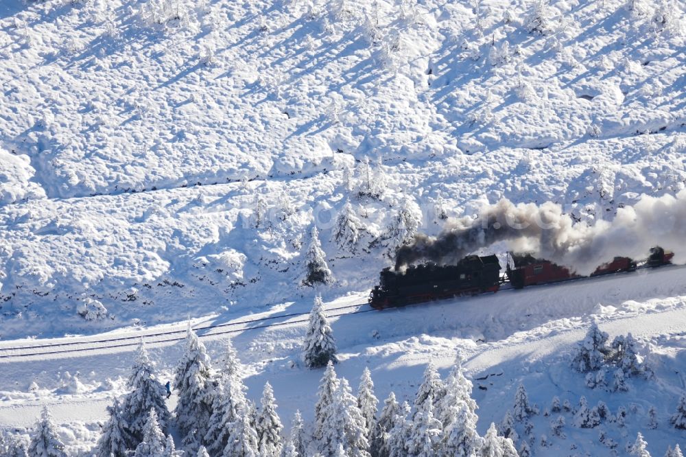Brocken from the bird's eye view: Wintry snowy railway Brockenbahn with a Mallet-Engine / steam locomotive / railcar, a narrow-gauge railway, during a trip at the Brocken mountain in Saxony-Anhalt
