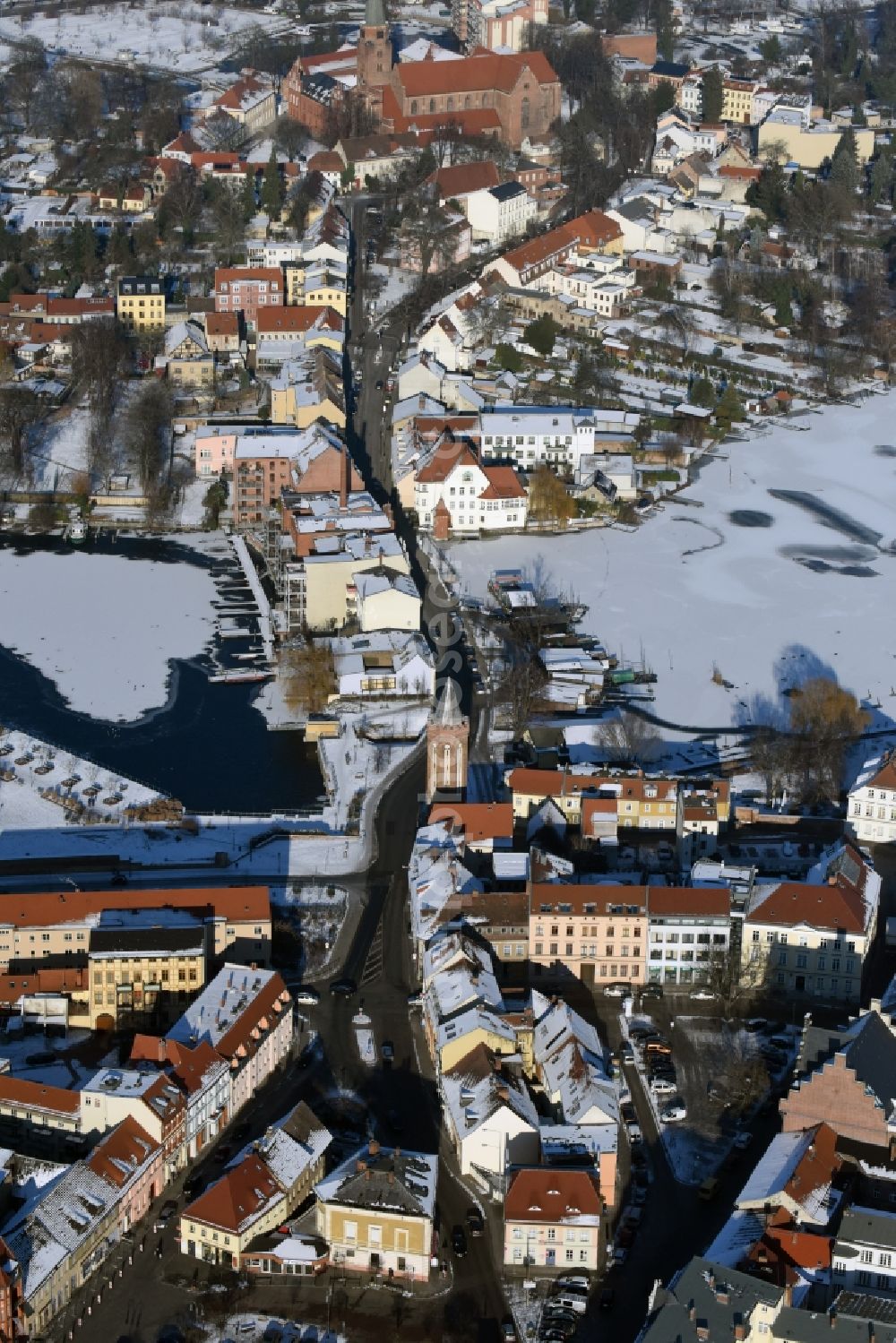 Aerial image Brandenburg an der Havel - Wintry snow covered Muehlendamm dam and street on the riverbank of the Southern Havel in Brandenburg an der Havel in the state of Brandenburg. The icy waters of the Southern arm of the river is visible